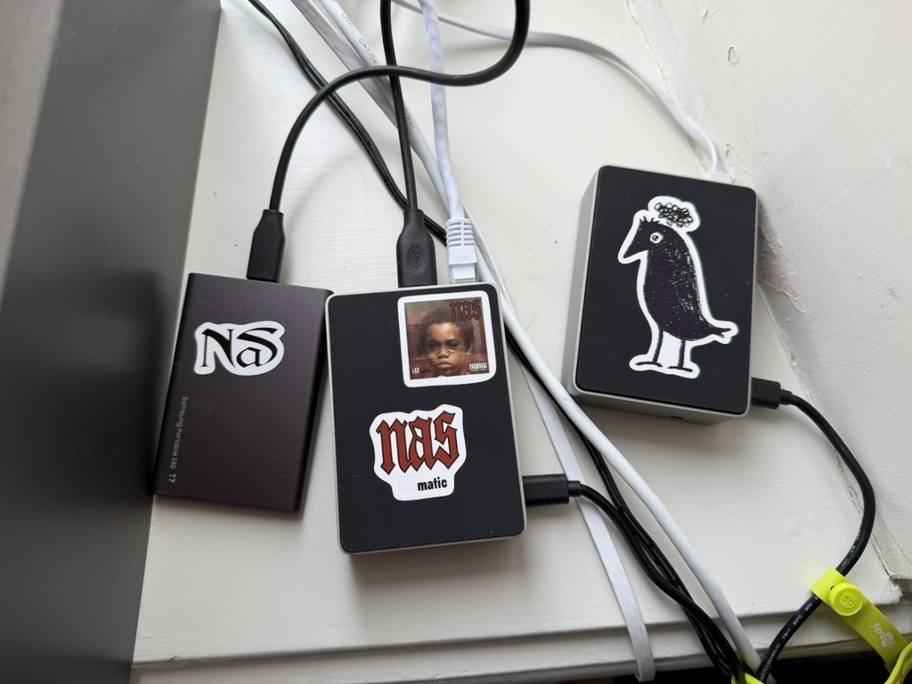 Raspberry Pi (Hugin, bird sticker) and two SSD drives with Nas rap stickers acting as NAS